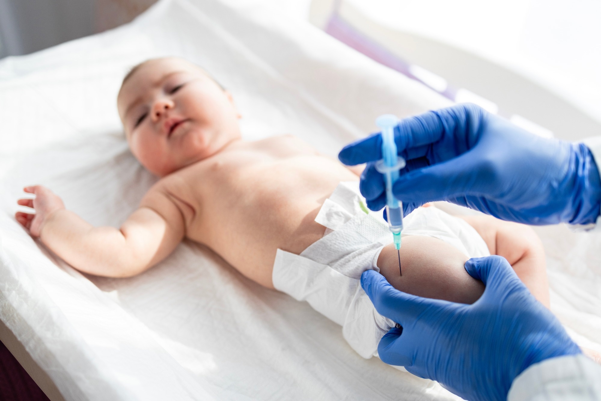 Doctor vaccinating baby newborn at maternity hospital.