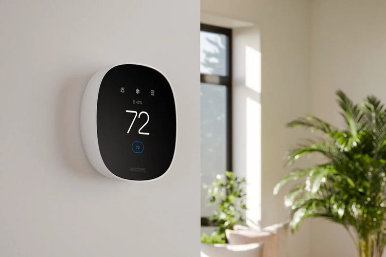 Ecobee's Essential thermostat on a white wall in a sunny room. 