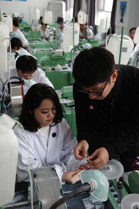 4月13日，昆玉职业技术学院玉雕课上，一位学生向沈罕询问玉石造型问题。新京报记者 戴轩 摄