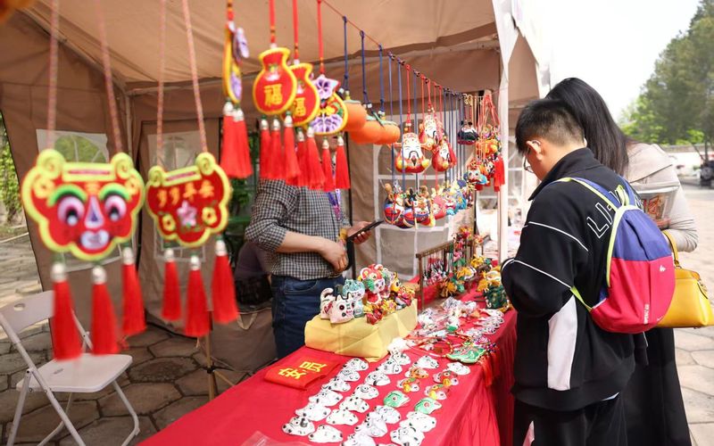 北京春季书市圆明园会场非遗文化体验区，游客在挑选非遗产品。新京报记者 浦峰 摄