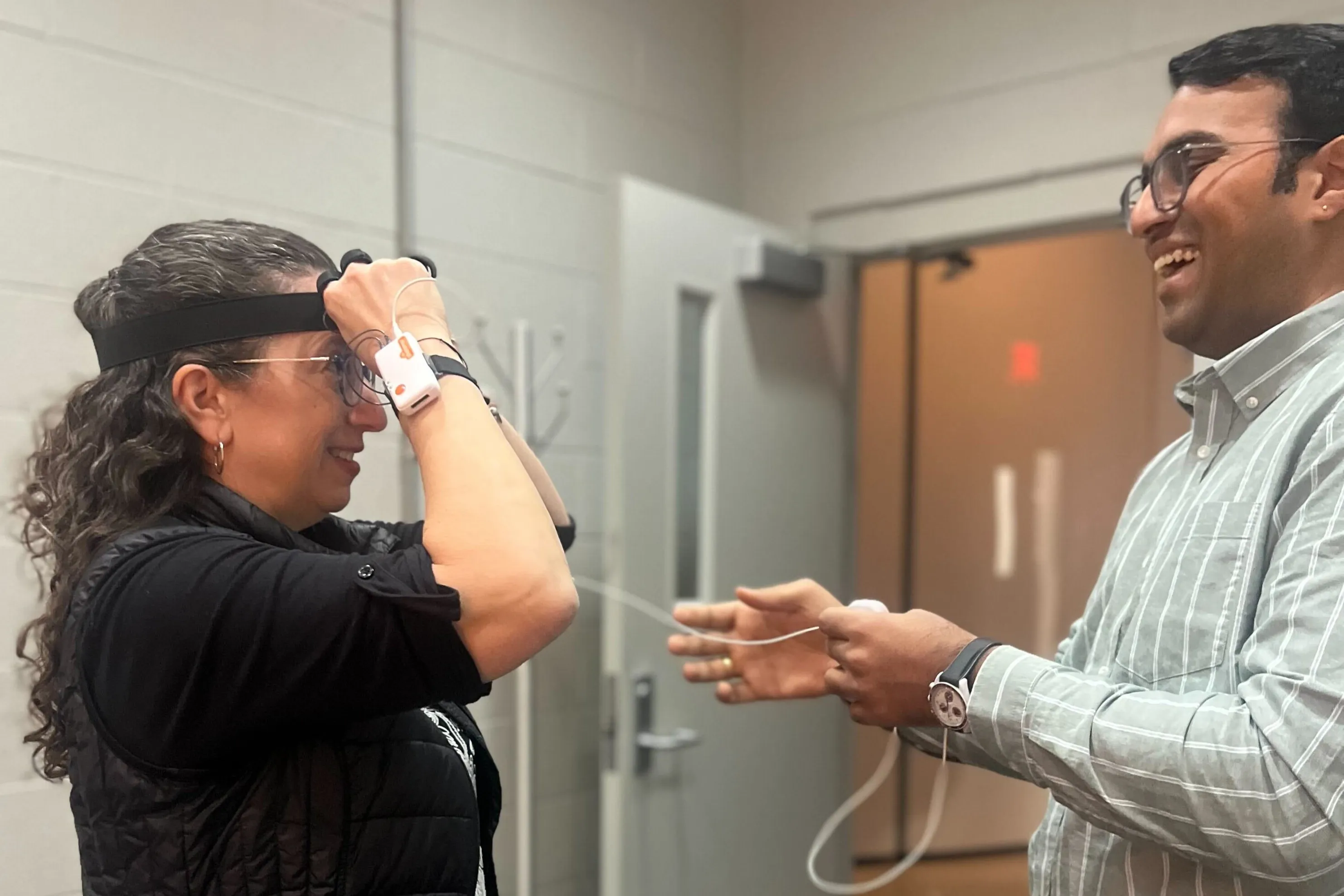 woman with sensors on her head as a laughing man looks on