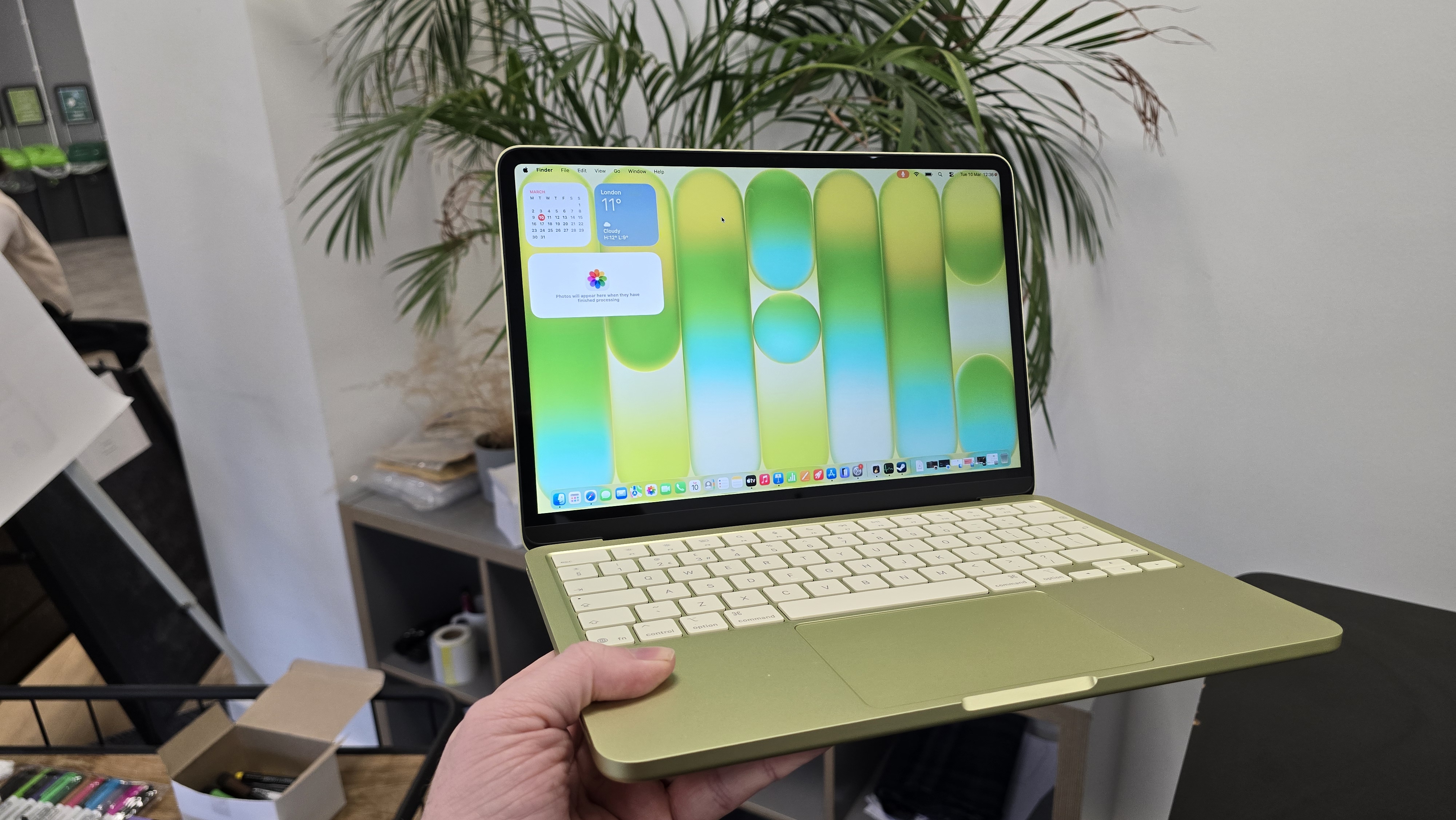 MacBook Neo laptop on a desk with plant in background