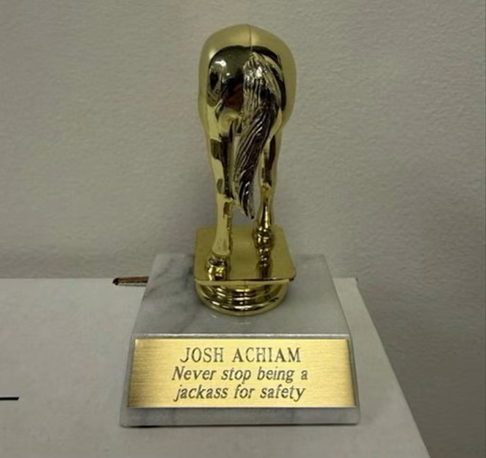A gold trophy shaped like the back of a donkey, with a plaque reading: ‘Josh Achiam. Never stop being a jackass for safety’