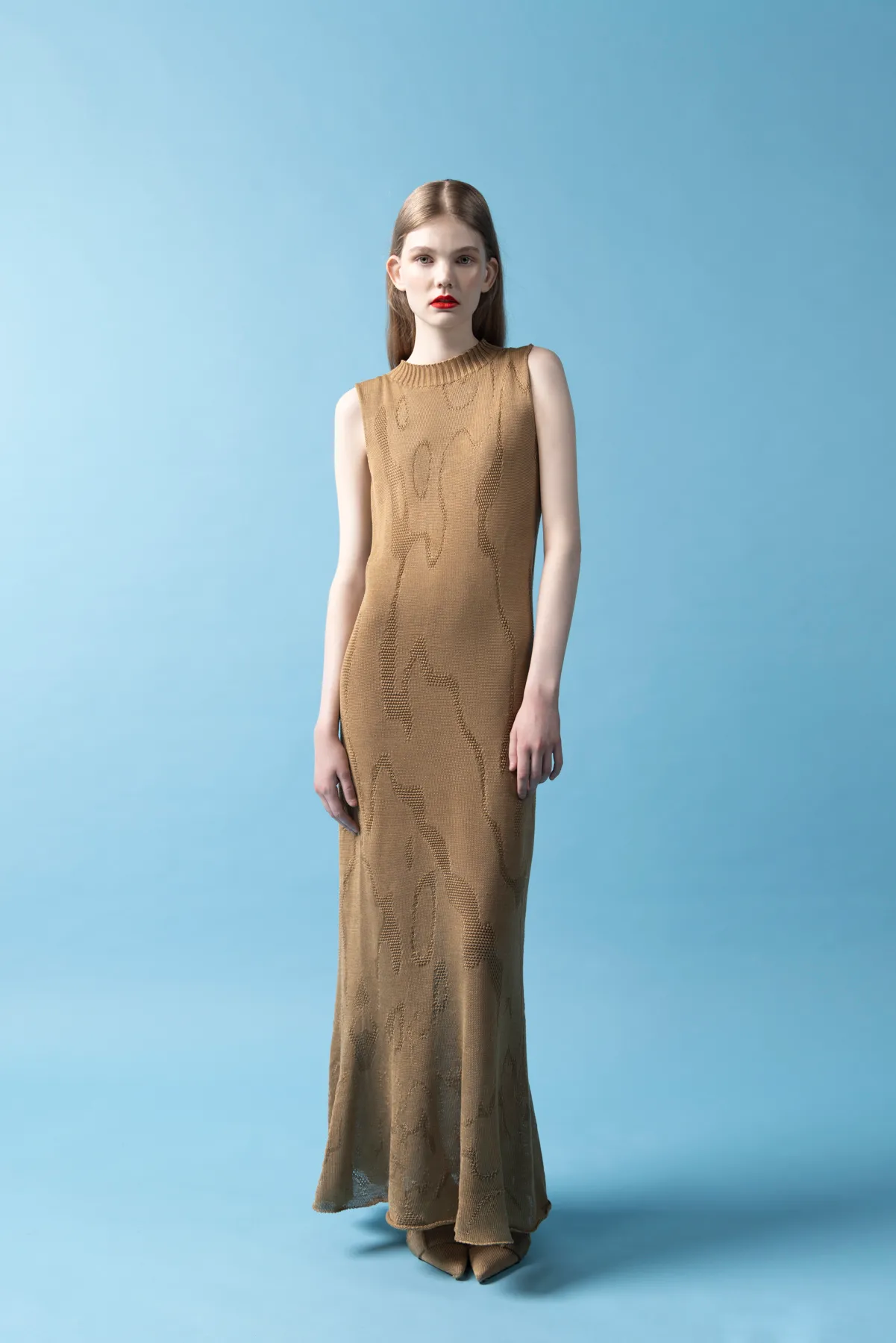 a model wearing a long brown dress