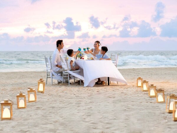 Family enjoys dinner on the beach Family enjoys dinner on the beach