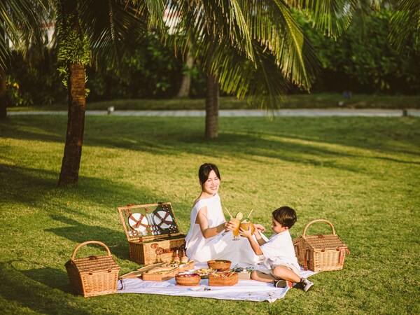 Mom and kid are enjoying picnic in the garden Mom and kid are enjoying picnic in the garden