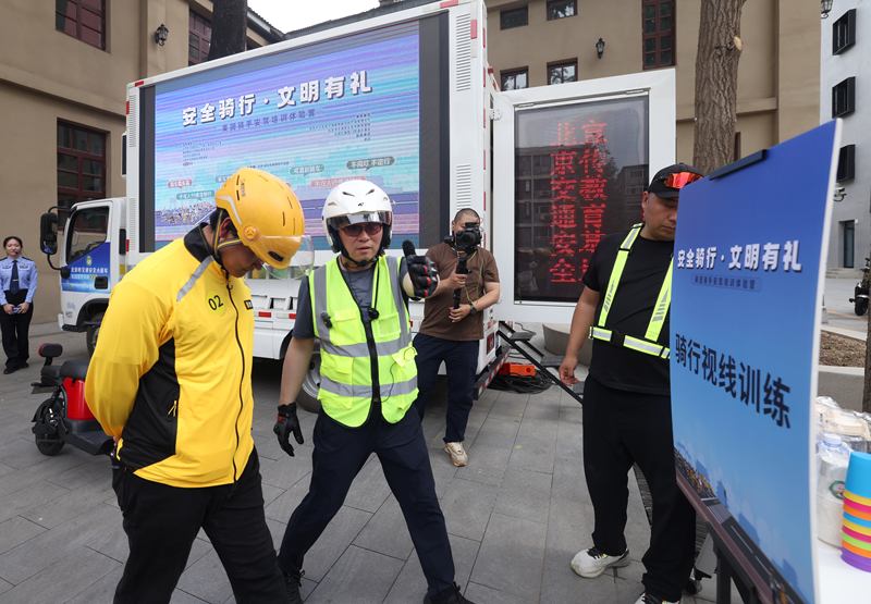 外卖骑手在模拟低头骑行。新京报记者 王贵彬 摄