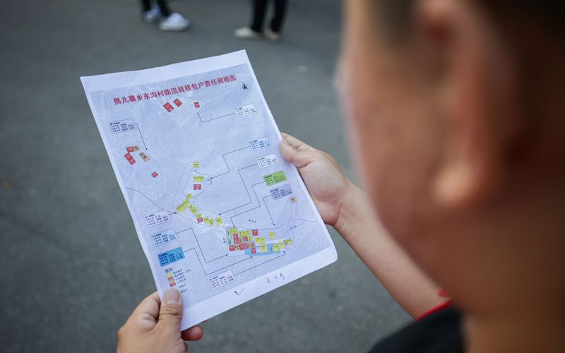 南岔村，工作人员根据防汛转移包护责任网络图挨家挨户通知。新京报记者 王子诚 摄