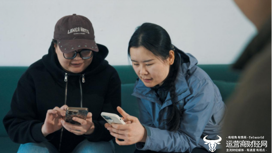△邻居小白老师向姜亚颖推荐使用拼多多app。薛凌枫 摄