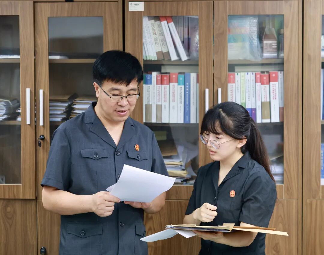 图为本案承办法官正在讨论案件情况。曹栋 摄