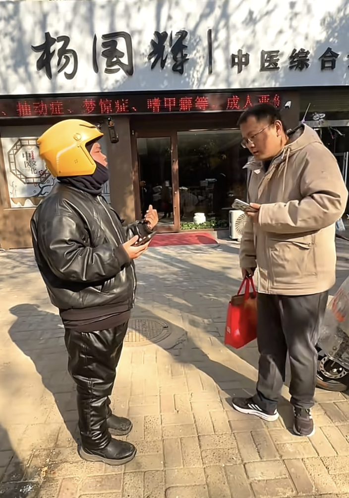 2024年冬，杨国辉（右）与李浩在诊所前交谈。 受访者供图